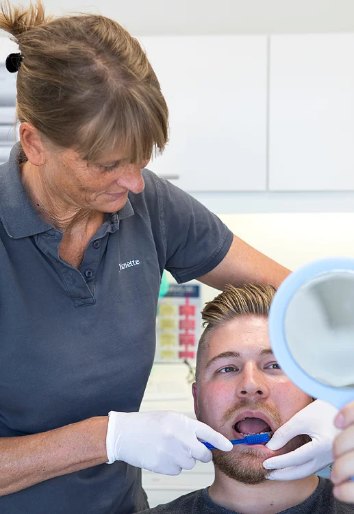 En tandlaege som boerster taender paa en patient